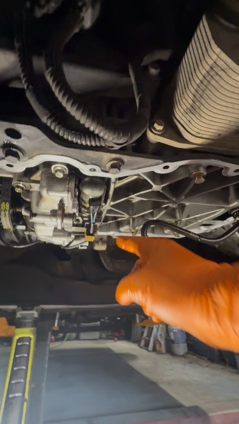Underside of a car on a ramp, a gloved hand pointing at the engine and sump area, at AGR Performance, Stafford